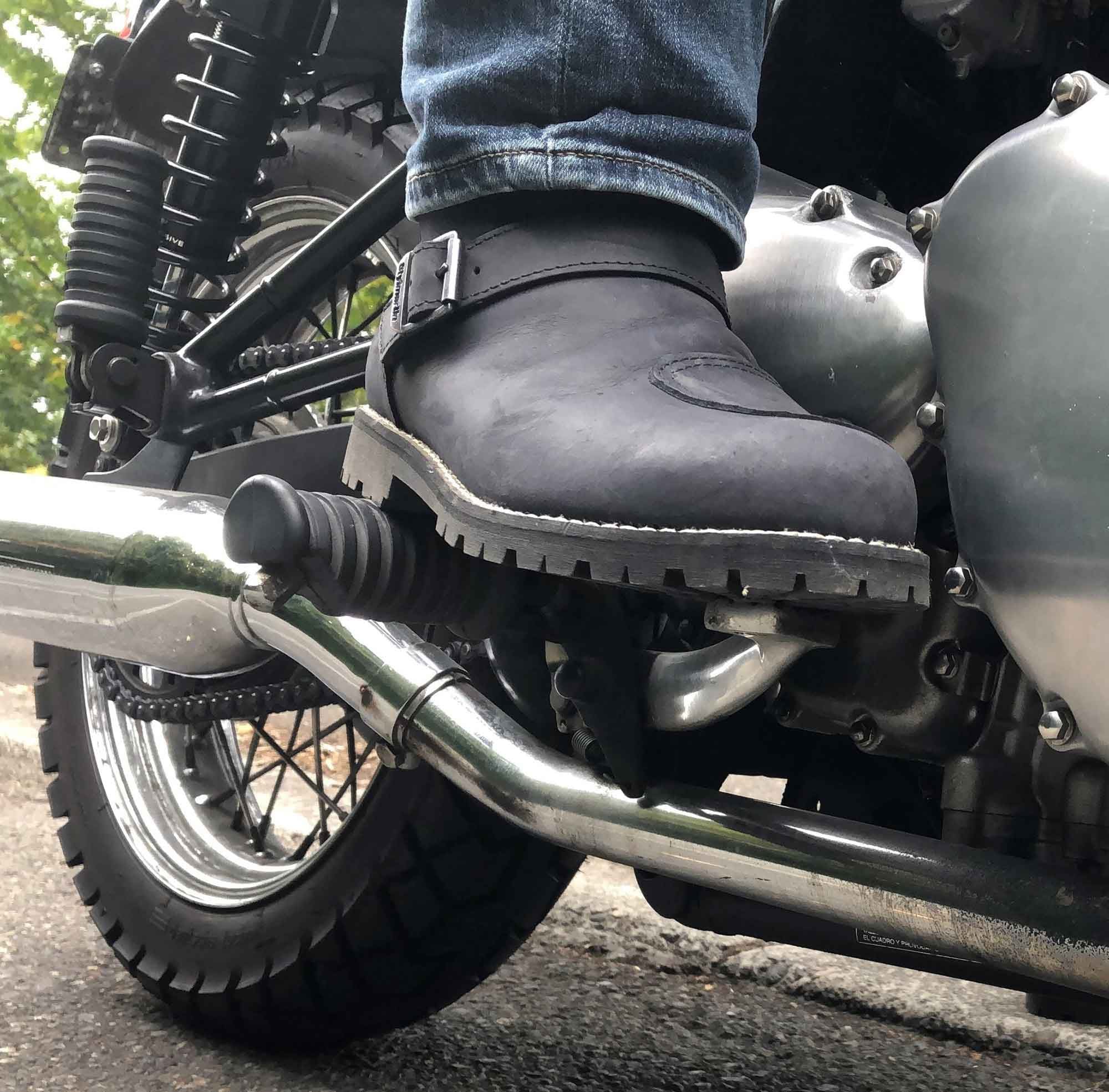 Classic engineer/moto boot cues include a heavy-duty sole and metal buckle at the ankle.