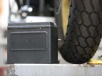 A new battery beside a tire.