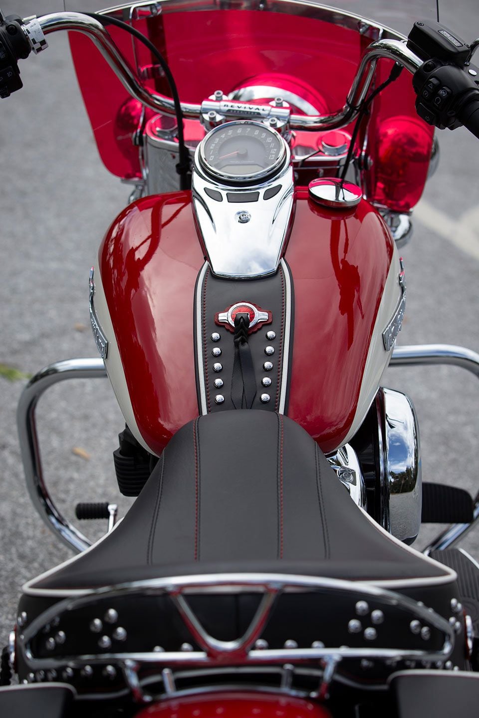 Sitting in the bike is also a trip back to the past, with a wide solo seat, leather tank strap, two-tone windshield, and analog-looking gauge taking up the view. Serialized “Hydra-Glide Revival” insert caps the handlebar riser.