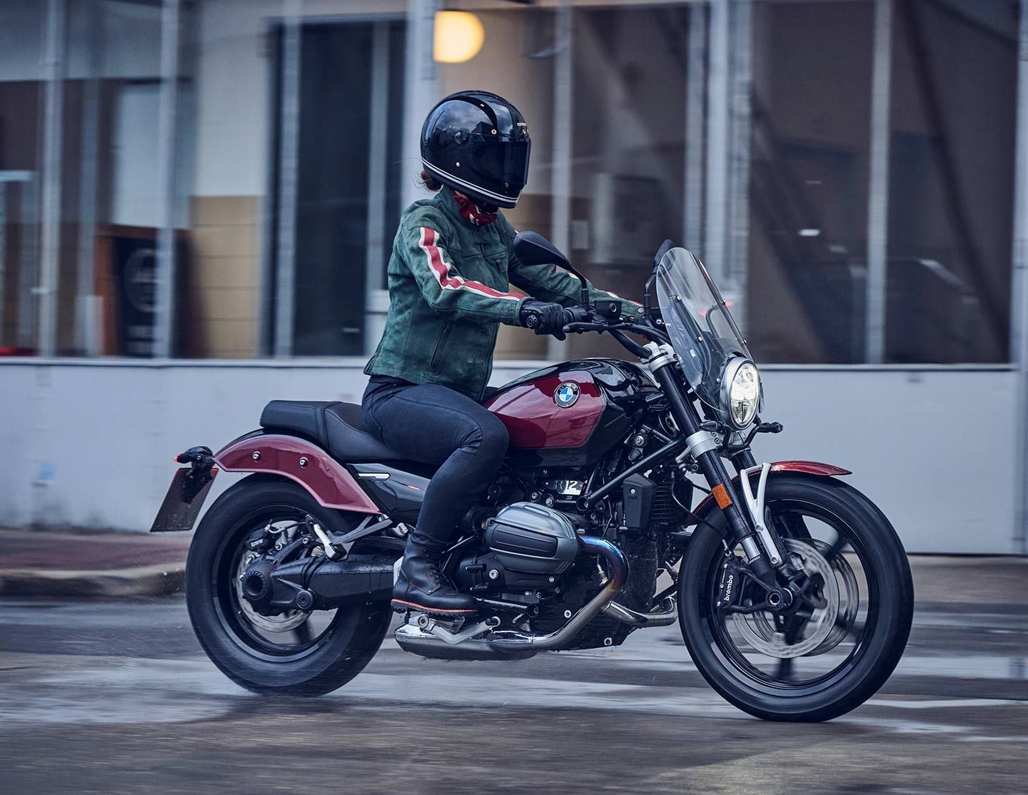 The 2024 BMW R 12 cruiser in Aventurin Red Metallic and an accessory windscreen.